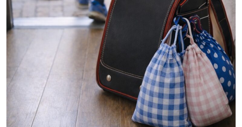 「小学1年生のランドセルと給食袋が玄関に置きっぱなしの様子」